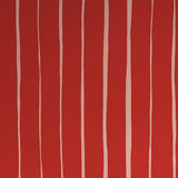 Detail of wallpaper in a playful irregular stripe print in cream on a red field.