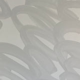Detail of wallpaper in an abstract paintstroke print in gray on a light gray field.