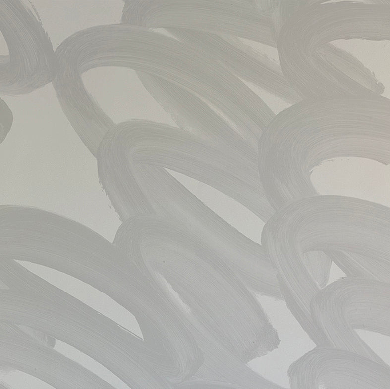 Detail of wallpaper in an abstract paintstroke print in gray on a light gray field.