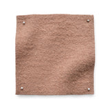 Wool boucle swatch pinned in all corners in soft pink.