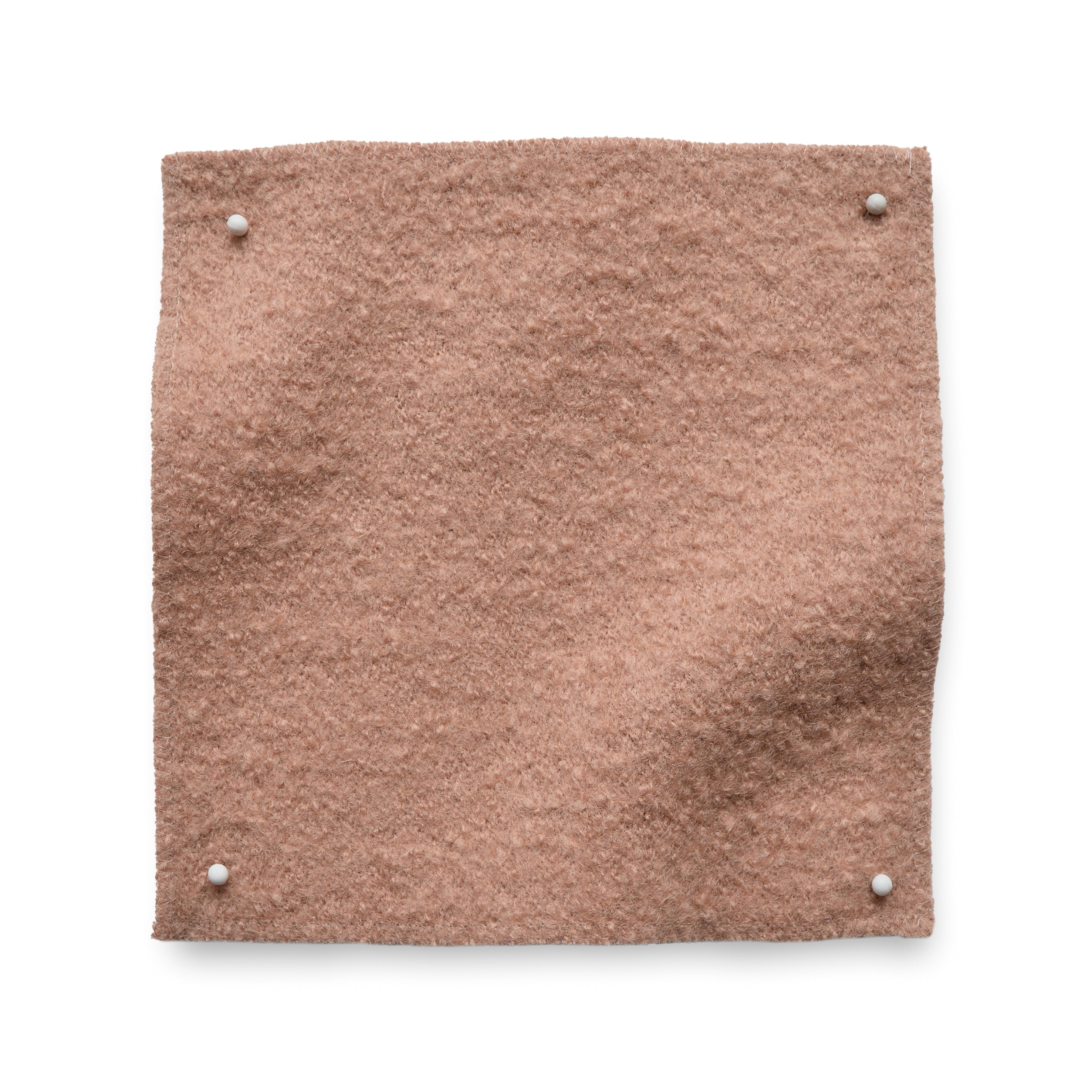 Wool boucle swatch pinned in all corners in soft pink.