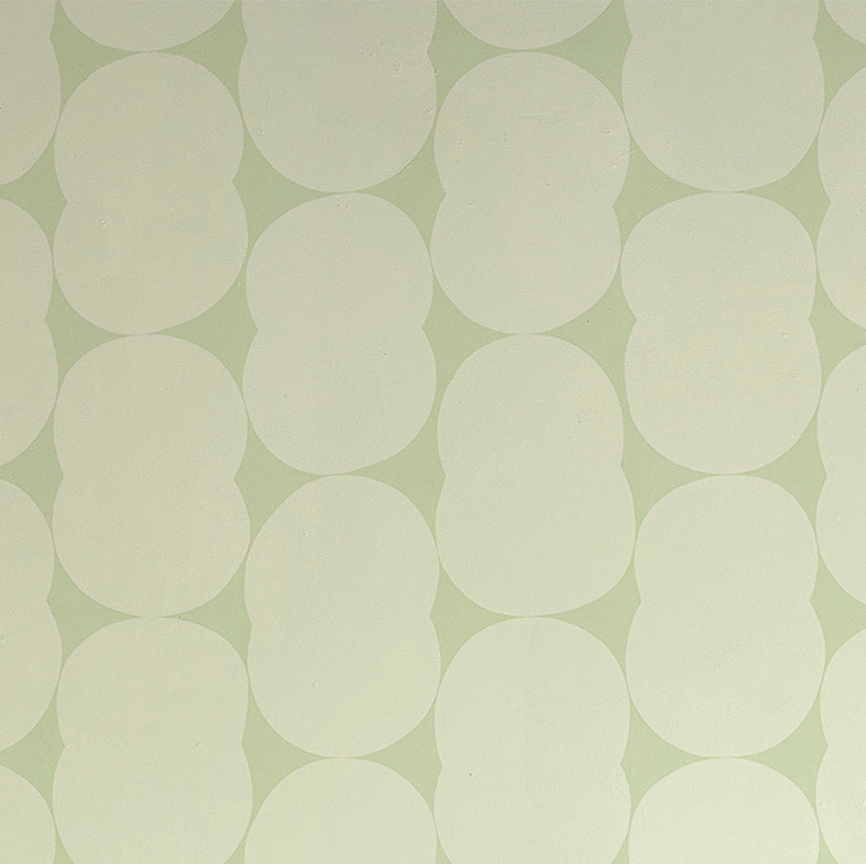 Detail of wallpaper in an abstract curvilinear pattern in cream on a light green field.