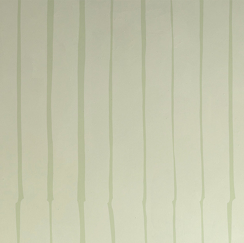 Detail of wallpaper in a playful irregular stripe print in light green on a cream field.