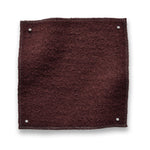 Wool boucle swatch pinned in all corners in wine red
