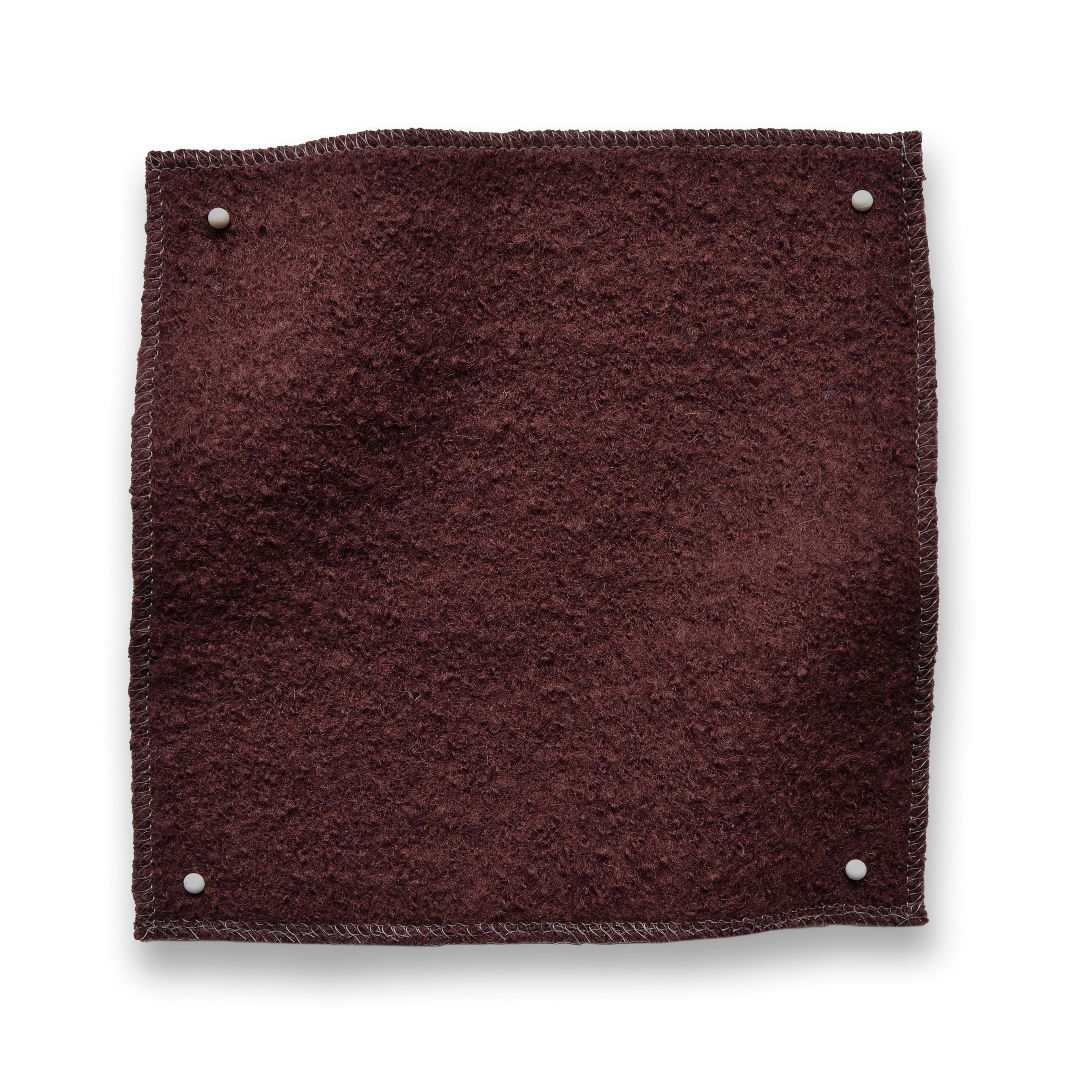 Wool boucle swatch pinned in all corners in wine red