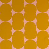 Detail of wallpaper in an abstract curvilinear pattern in mustard on a pink field.
