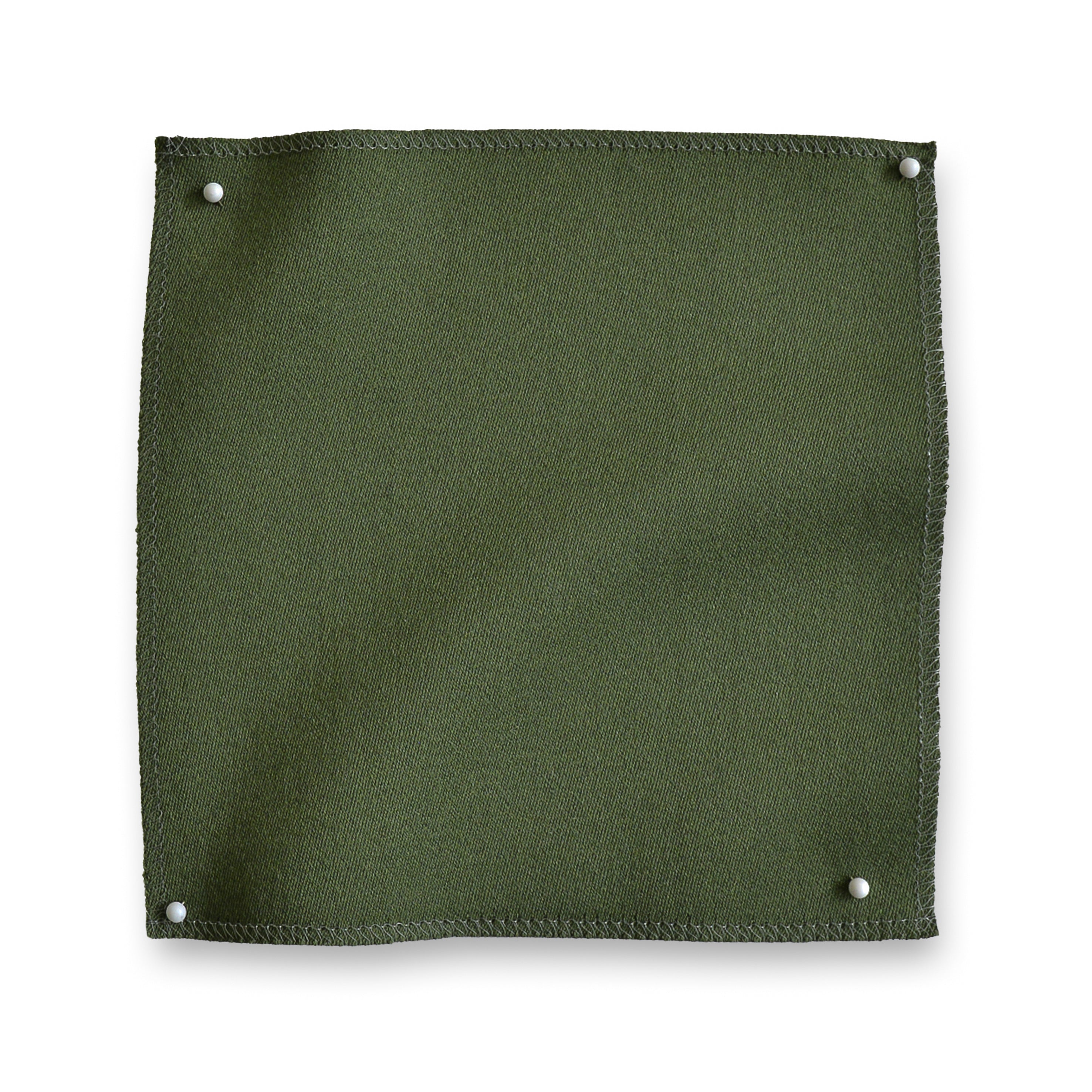 Wool sateen swatch pinned in all corners in moss green