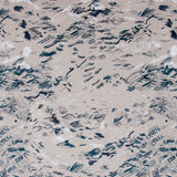 Detail of fabric in a painterly seaside print in navy and white on a tan field.