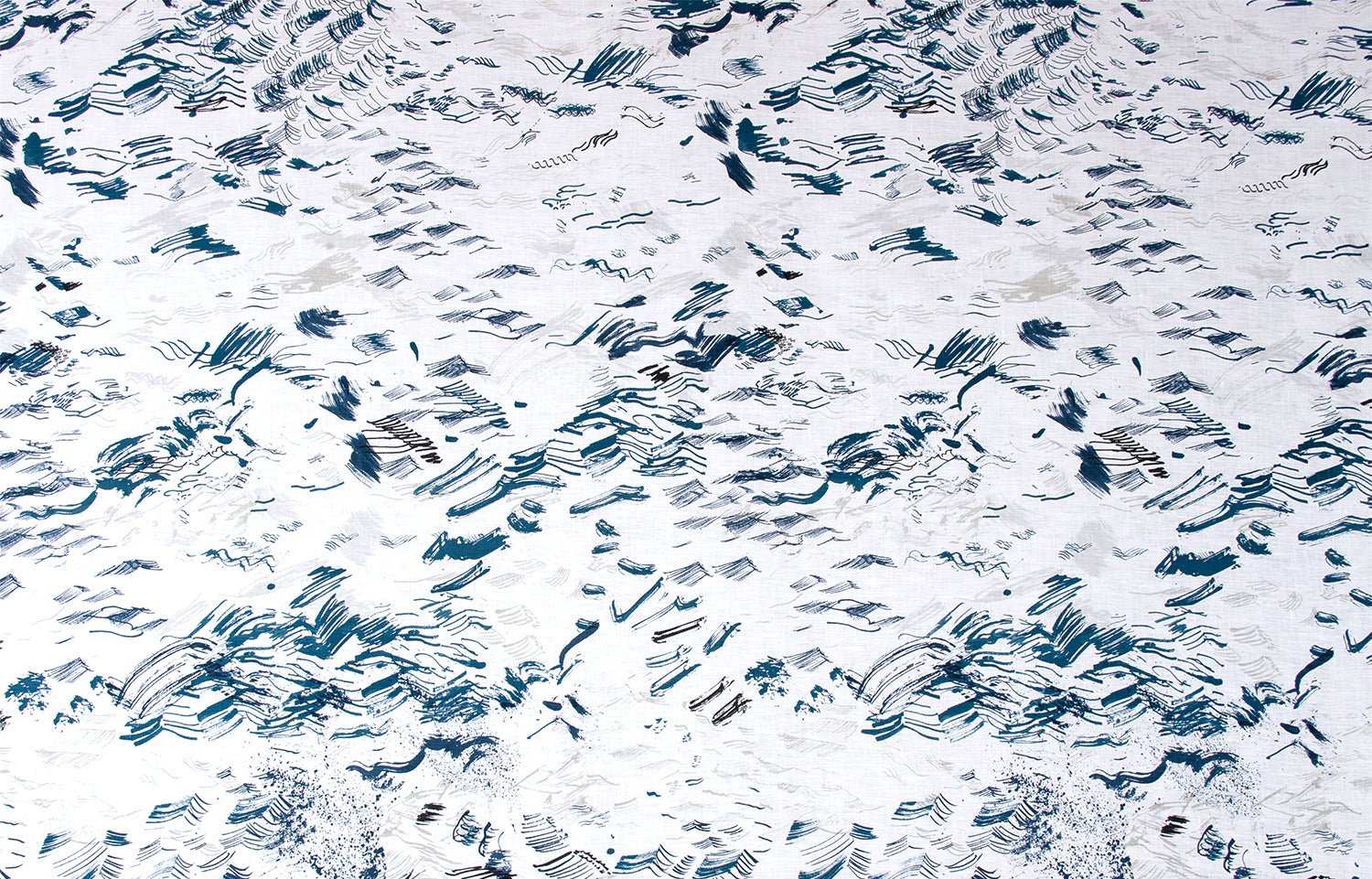 Detail of fabric in a painterly seaside print in shades of blue and gray on a white field.