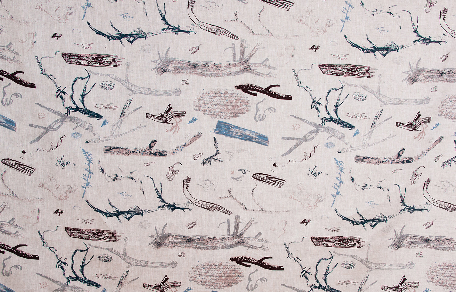 Detail of fabric in a painterly tree branch print in shades of brown and blue on a tan field.