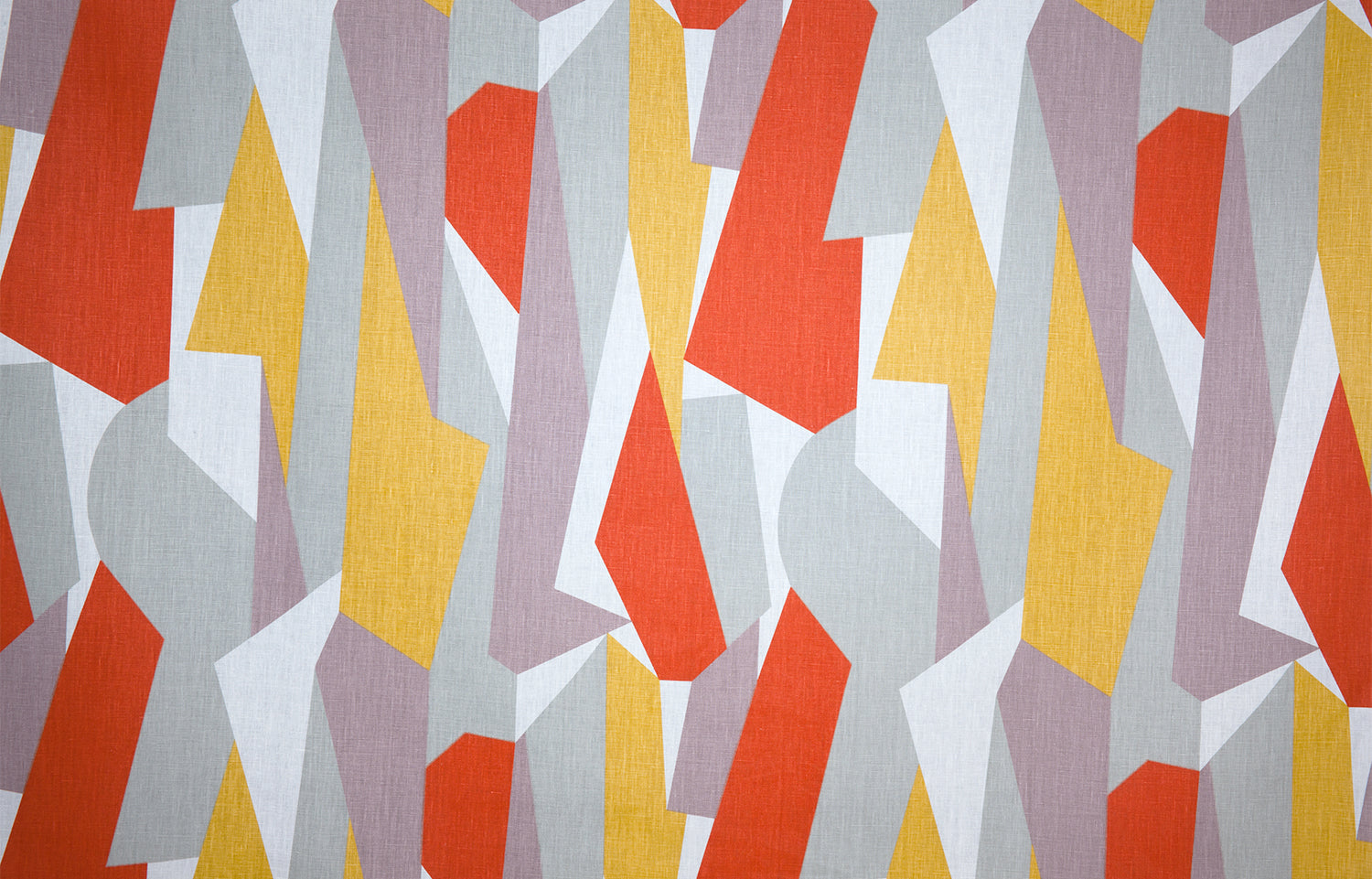 Detail of fabric in an abstract geometric print in yellow, red, white and gray.