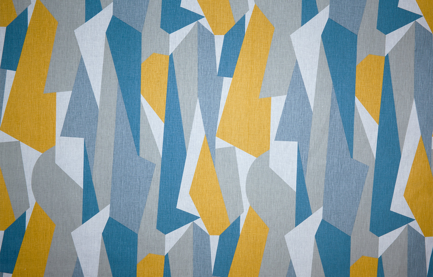Detail of fabric in an abstract geometric print in blue, gray, yellow and white.