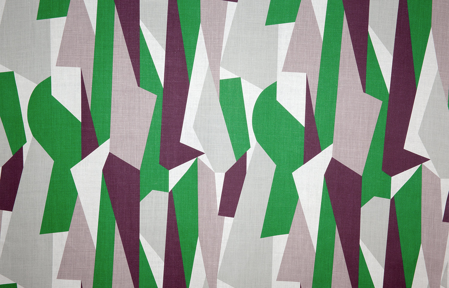 Detail of fabric in an abstract geometric print in gray, green, purple and white.