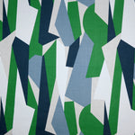 Detail of fabric in an abstract geometric print in blue, green, tan and white.