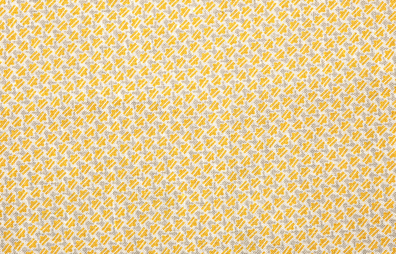 Detail of fabric in a dense geometric print in yellow, gray and cream.