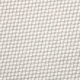 Detail of fabric in a dense geometric print in gray, white and cream.