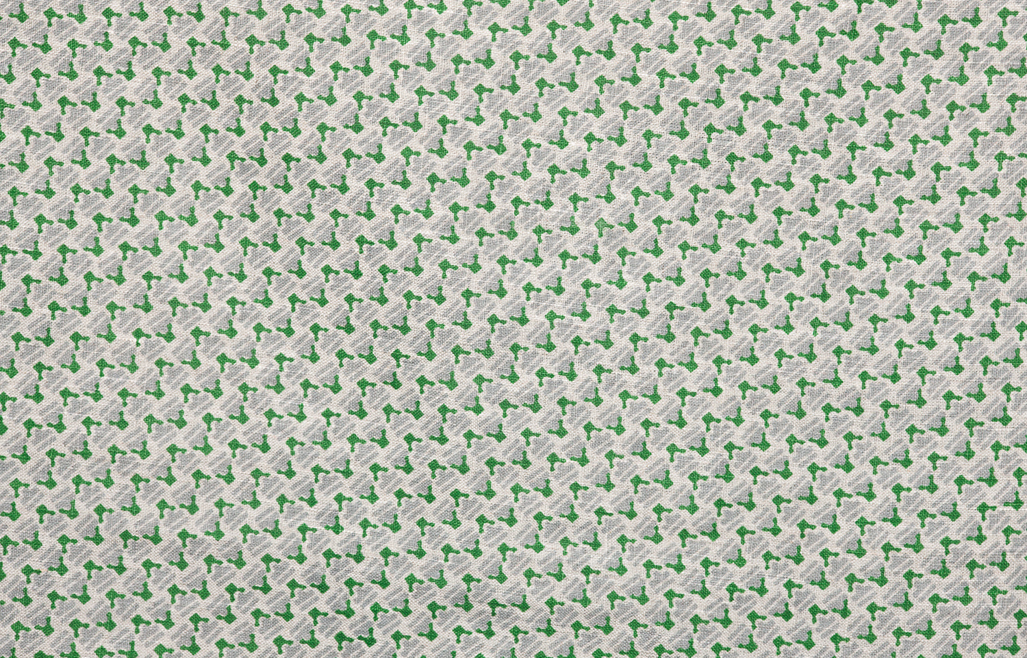 Detail of fabric in a dense geometric print in gray, green and cream.