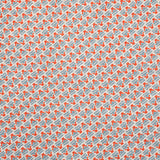 Detail of fabric in a dense geometric print in red, blue and cream.