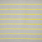 Detail of fabric in a horizontal striped print in yellow and white on a gray field.