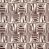 Detail of fabric in a dense geometric print in brown on a cream field.