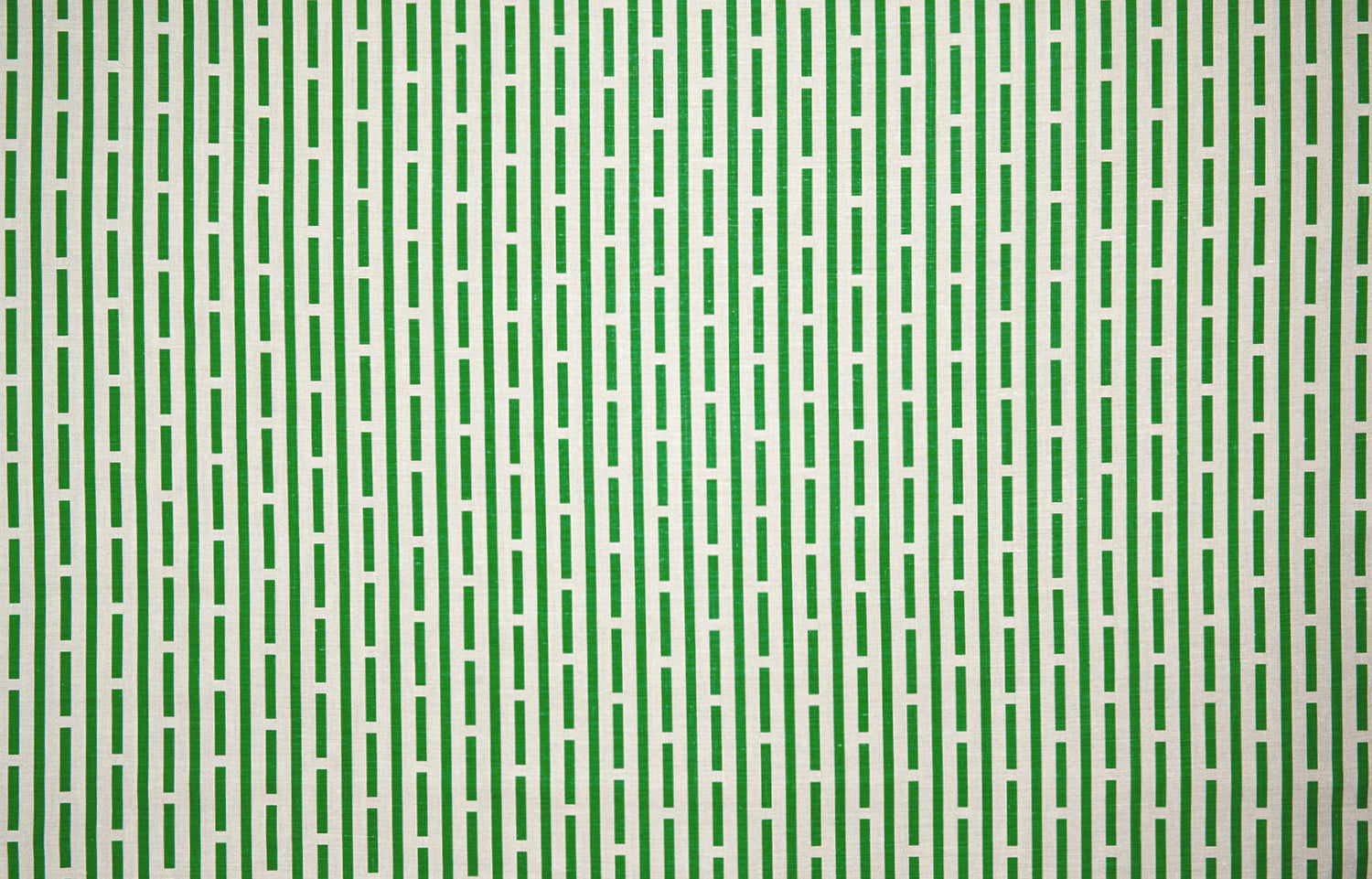 Detail of fabric in a broken line print in green on a cream field.