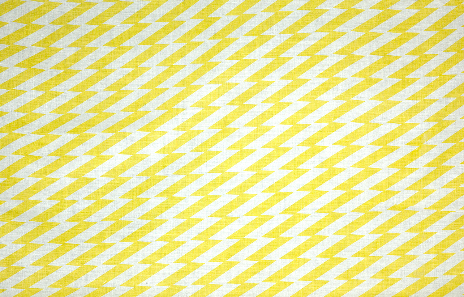 Detail of fabric in a zigzag stripe print in yellow on a white field.