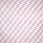 Detail of fabric in a zigzag stripe print in pink on a white field.