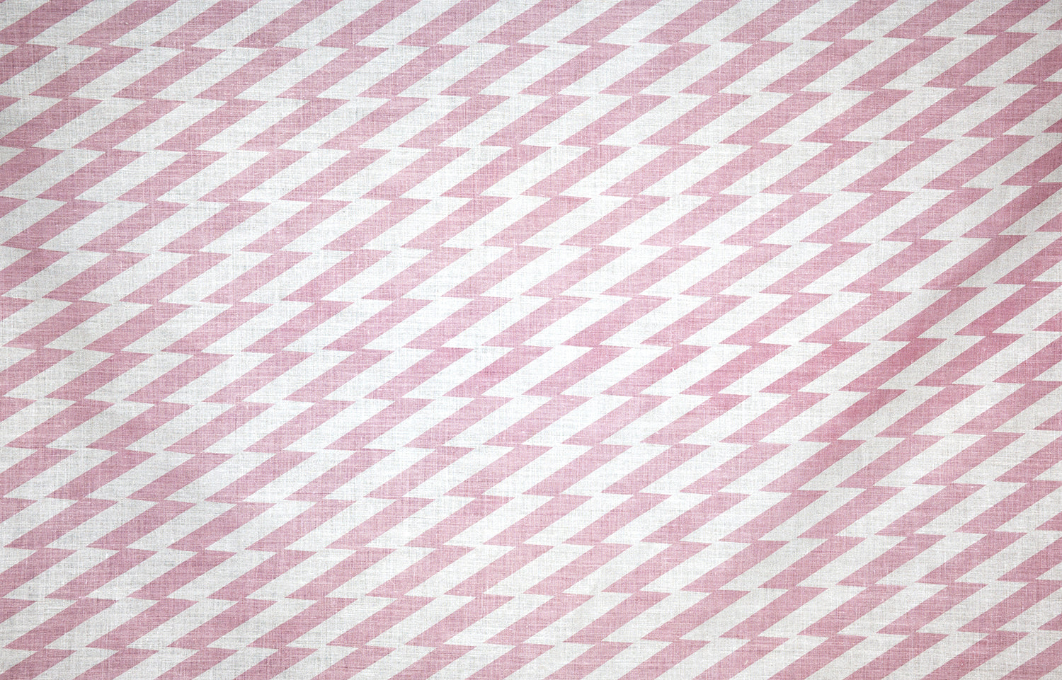 Detail of fabric in a zigzag stripe print in pink on a white field.