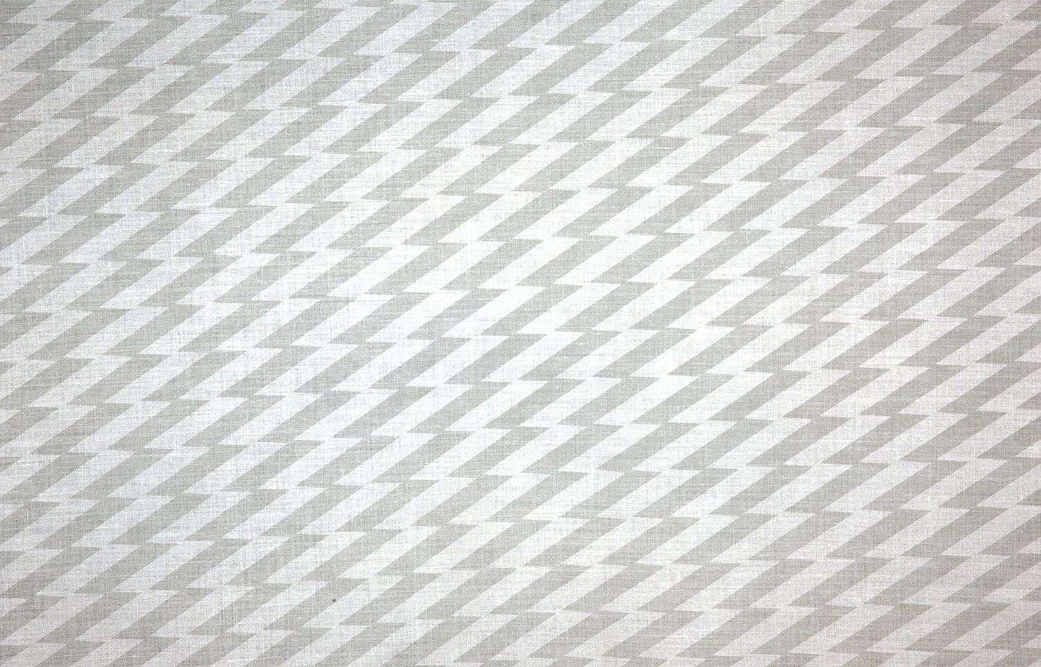 Detail of fabric in a zigzag stripe print in gray on a white field.