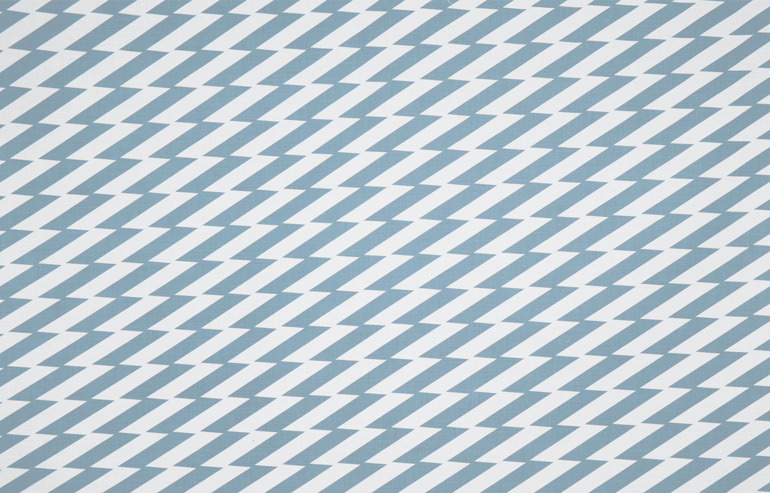 Detail of fabric in a zigzag stripe print in blue-gray on a white field.