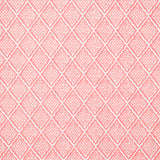 Detail of fabric in a diamond lattice print in white on a pink field.