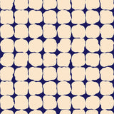 Wallpaper in a repeating blot print in cream on a dark blue field.