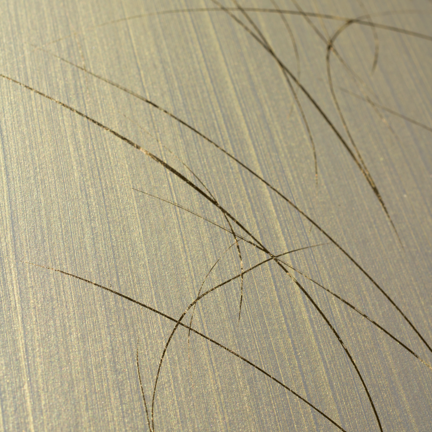 Wide-angle shot of wallpaper in an elongated paint splatter pattern in gold on a metallic field.