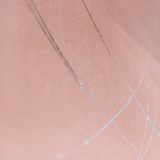 Wide-angle shot of wallpaper in an abstract curved line pattern in silver on a pink field.