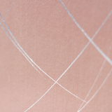 Wide-angle shot of wallpaper in an abstract curved line pattern in silver on a pink field.