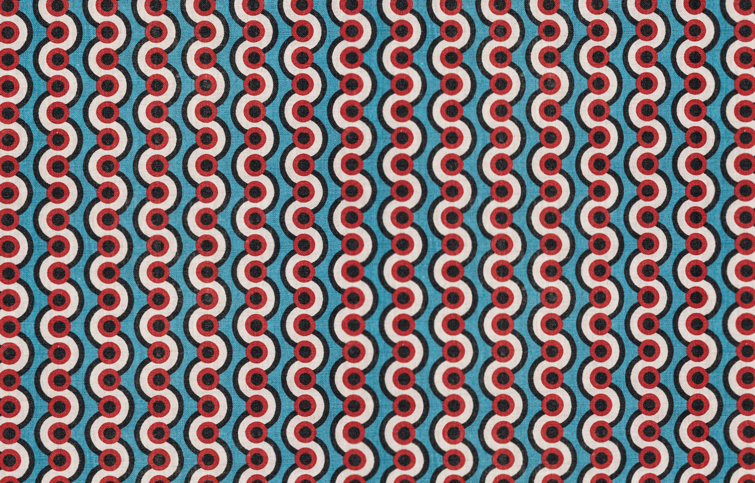 Detail of fabric in a playful curving stripe print in red, white and black on a blue field.