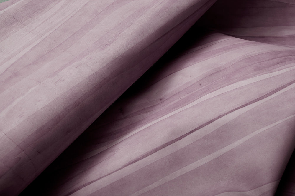 Draped upholstery leather in purple with an abstract stripe overlay in shades of dark purple.