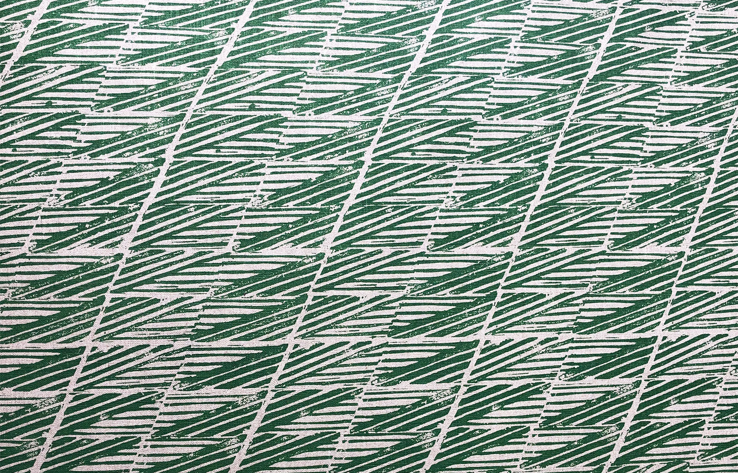 Detail of fabric in a textural geometric stripe in green on a cream field.