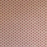 Detail of wallpaper in a minimalist quatrefoil pattern in red on a cream field.