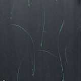 Detail of a wallpaper in an elongated paint splatter pattern in metallic turquoise on a navy field.