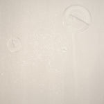 Detail of a wallpaper in a paint splatter print in metallic cream on a cream field.