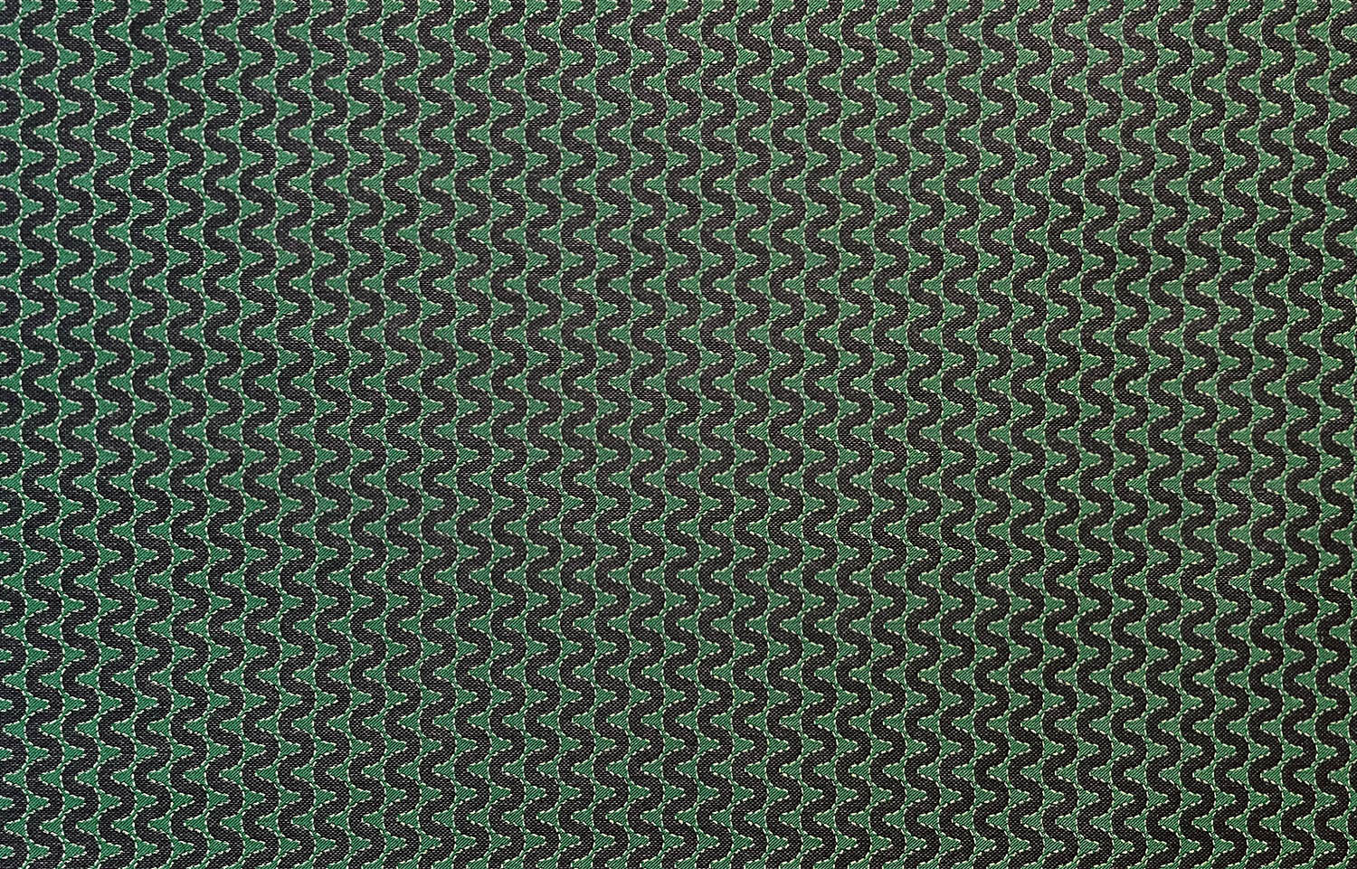Detail of fabric in a playful curving stripe in gray on a green field.