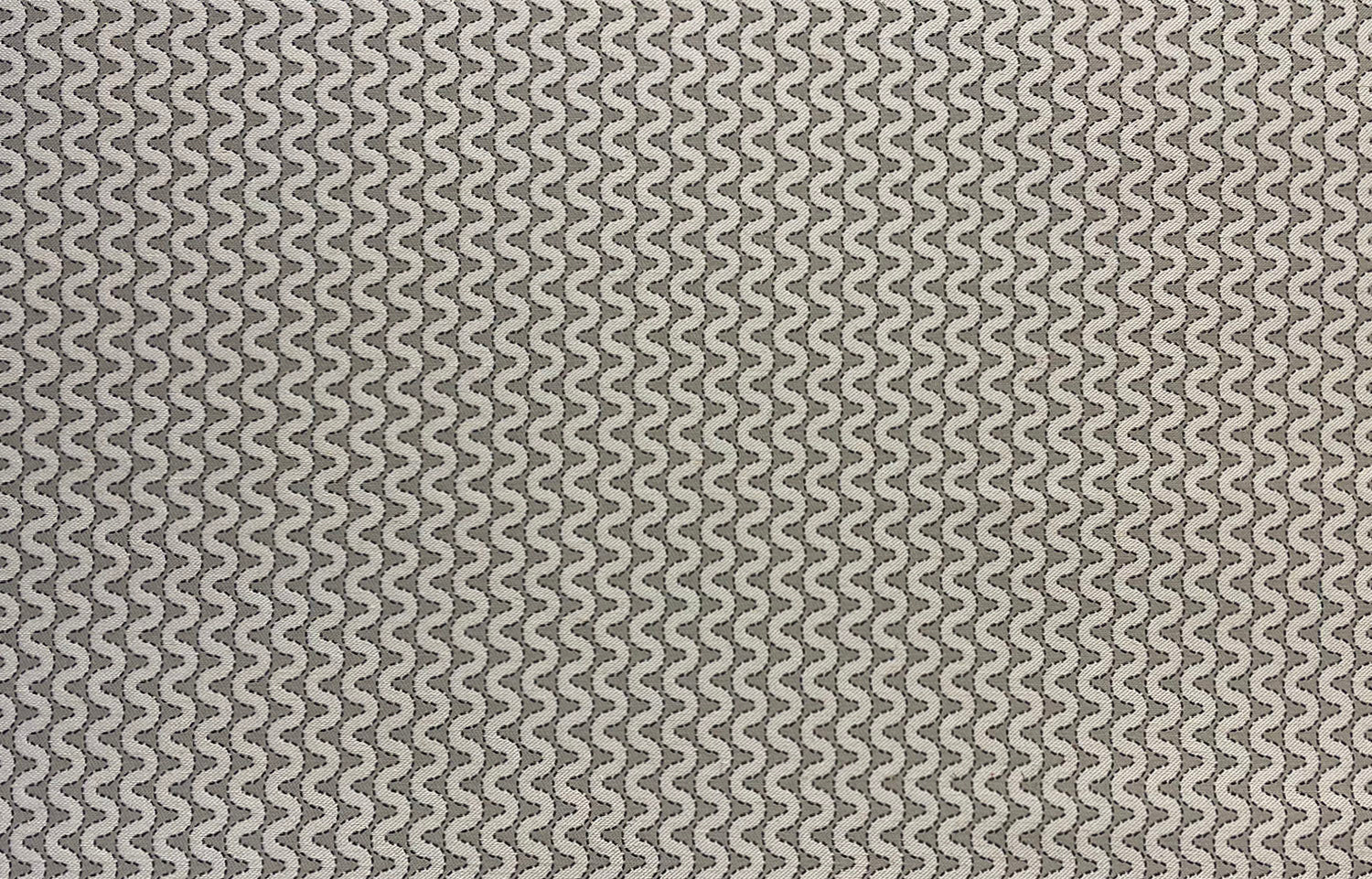 Detail of fabric in a playful curving stripe in cream on a gray field.