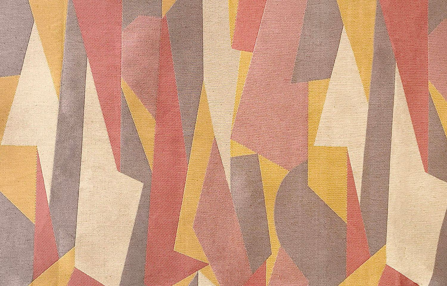 Detail of fabric in an abstract geometric print in pink, yellow, tan and brown.