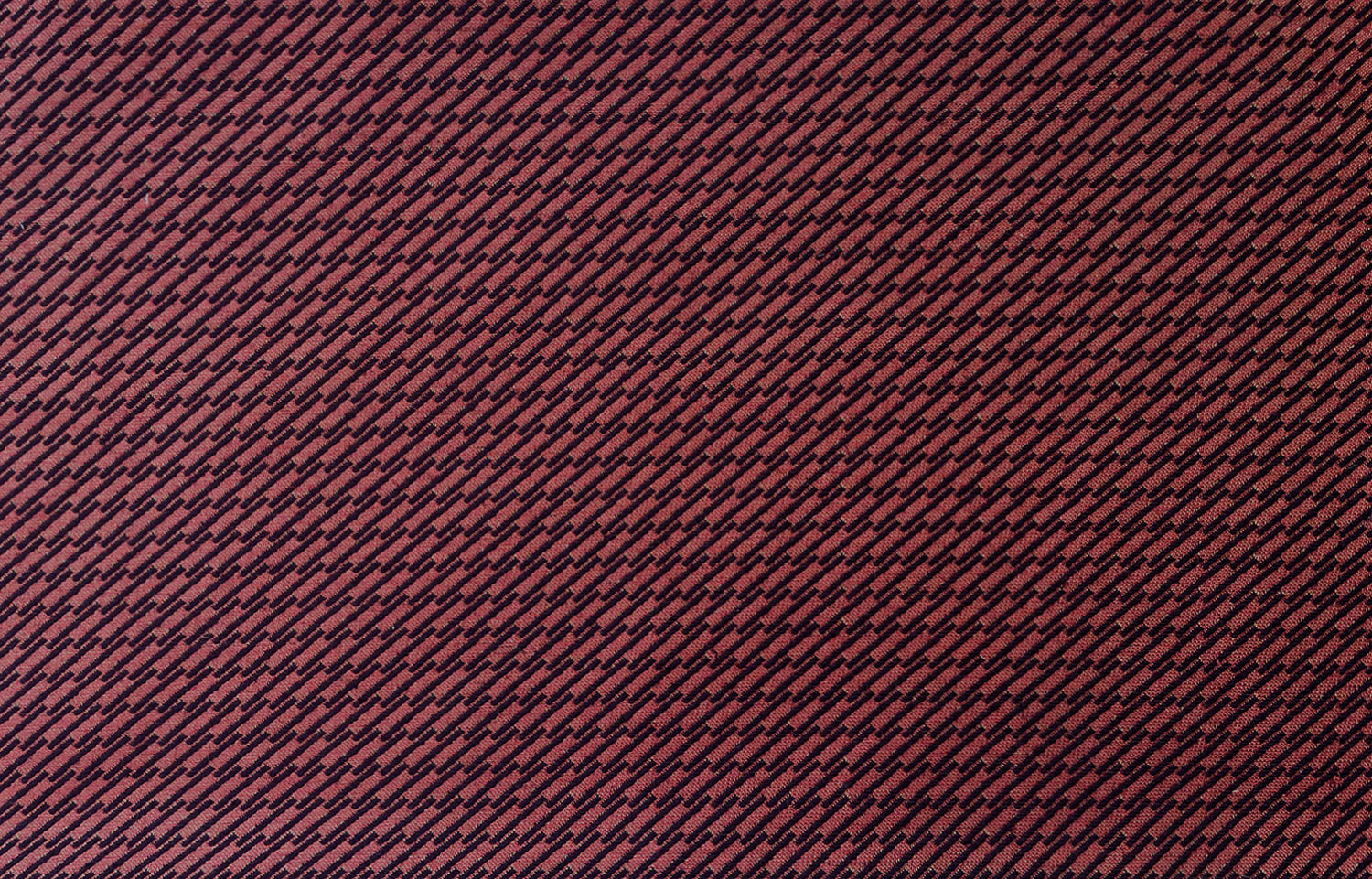 Detail of fabric in a matchstick grid print in black on a red field.