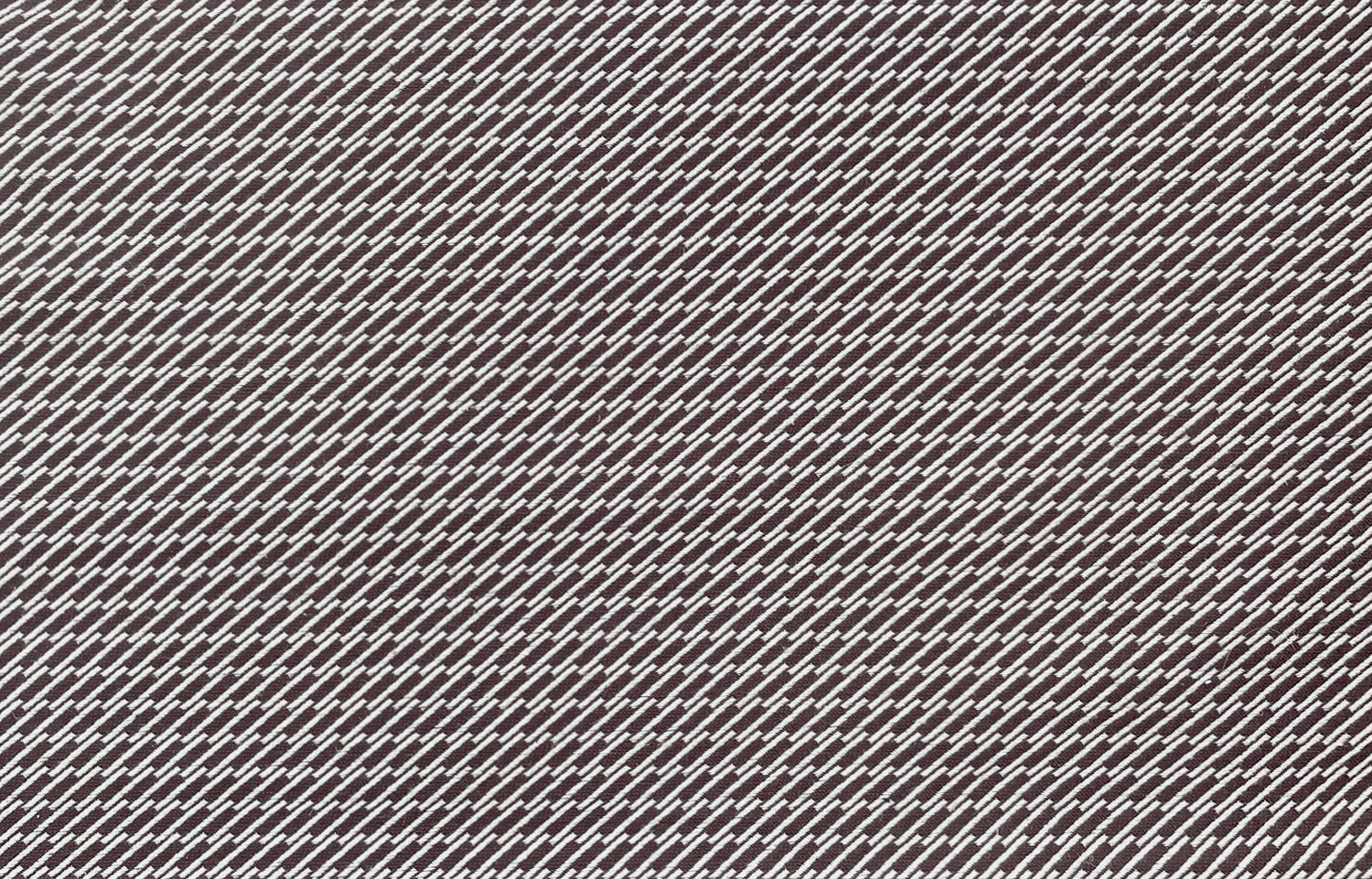 Detail of fabric in a matchstick grid print in white on a brown field.
