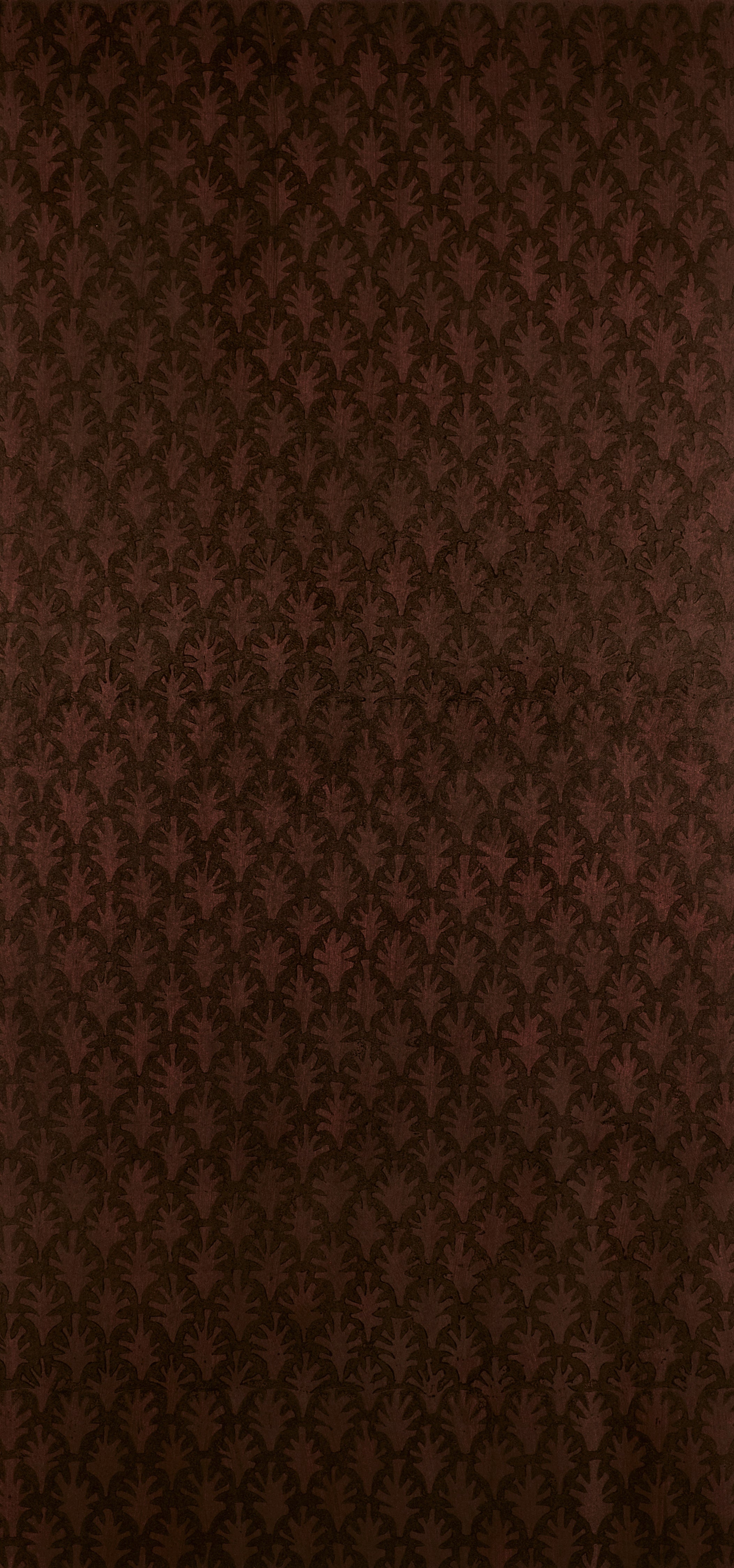 Detail of wallpaper in a repeating botanical grid print in burnt orange on a brown field.