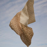 Floral fabric tossed in the air against a blue sky