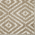 Close-up of a textured beige and white woven diamond pattern rug. 
