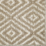 Close-up of a textured beige and white woven diamond pattern rug. 